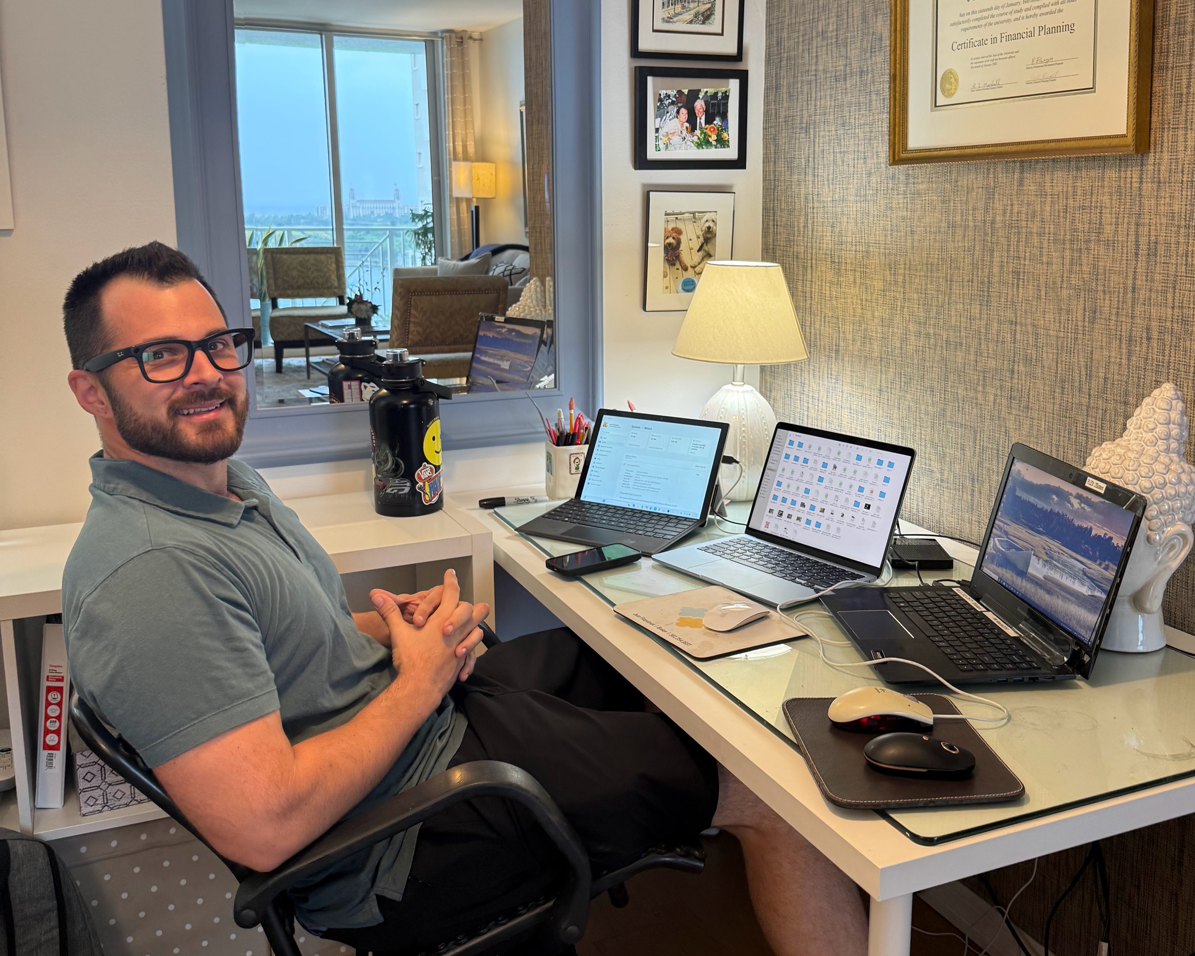 Brian sitting at his home office desk with three laptops, providing in-home computer repair and IT support in Palm Beach County